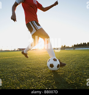 Razza mista donna calci palla calcio Foto Stock