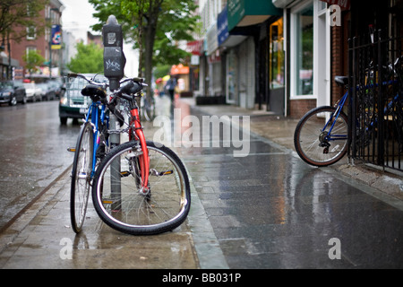 Bicicletta con ruota inclinata concatenati a un sondaggio Foto Stock