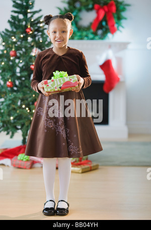 African American Girl in abito azienda regalo di Natale Foto Stock