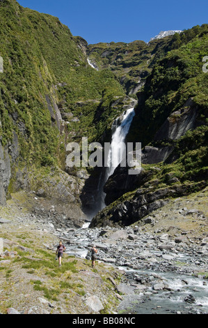 Gli escursionisti a cascata in Occidente Matukituki valle Mount aspiranti Parco Nazionale dell'Isola del Sud della Nuova Zelanda Foto Stock