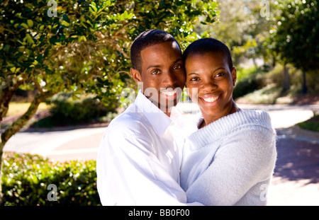 Il nero americano africano giovane felici insieme nella luce del sole a casa insieme in cantiere e snuggling Foto Stock