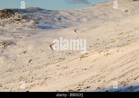 La zona al di sotto del Scafell noto come pietre di cava con il lato di Lingmell ricoperta di neve e inondate di luce della sera. Foto Stock