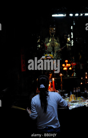 Femmina con devoto bruciare bastoncini di incenso. L'imperatore Jade Pagoda (Chua Ngoc Hoang o Phuoc Hai Tui), la città di Ho Chi Minh, Vietnam Foto Stock