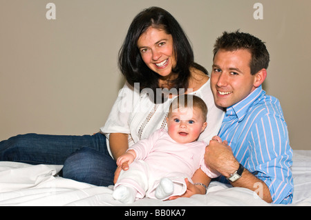 Chiudere orizzontale su ritratto di un sei mesi bambina e i suoi orgogliosi genitori Foto Stock