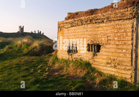 Scatola del montante e il castello di Dunstanburgh all'alba Foto Stock