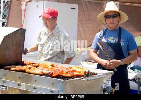 Cuochi Hmong tostatura di pollo e salsiccia per un ristorante esterno. Hmong Sports Festival McMurray campo St Paul Minnesota USA Foto Stock