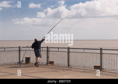 Un uomo pesca in mare la fine di Southwold Pier in Southwold,Suffolk, Regno Unito Foto Stock