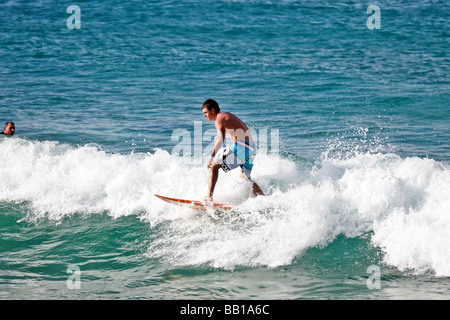 Surfer acquisisce un'onda per una corsa in riva tardo pomeriggio
