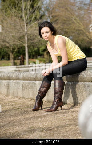 Outdoor ritratto di un bel giovane ragazza adolescente seduti all'aperto su una giornata d'estate Foto Stock