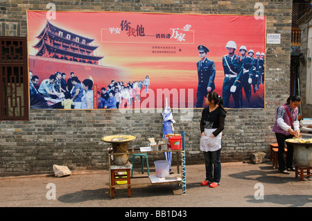 Propaganda di governo murale over street vendor Jianshui in Cina Foto Stock