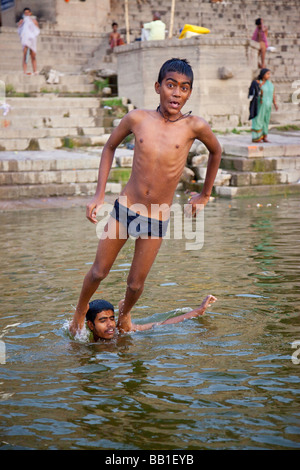 Ragazzo indù che salta da spalle nel fiume Gange a Varanasi India Foto Stock