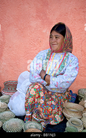 Tarahumara nativa indiana donna si siede con tessuto cesti che essa produce e vende ai turisti Divisadero, rame Canyon, Messico Foto Stock