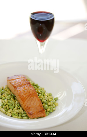 Fresh Filetto di salmone alla griglia o Bistecca con Edamame Fagioli e un bicchiere di vino rosso con il n. di persone Foto Stock