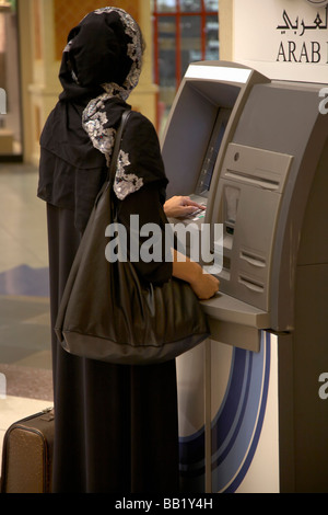 Vista posteriore della donna all'ATM, Dubai, Emirati arabi uniti Foto Stock