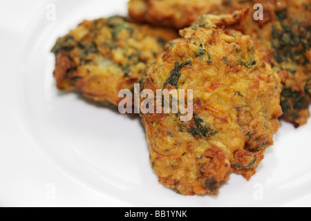 Autentica fresche fritte in Stile Indiano Onion Bhaji snack salati con n. di persone servite su un piatto Foto Stock