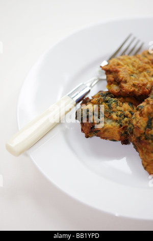 Autentica fresche fritte in Stile Indiano Onion Bhaji snack salati con n. di persone servite su un piatto Foto Stock