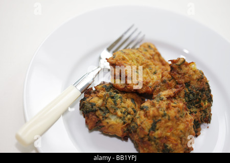 Autentica fresche fritte in Stile Indiano Onion Bhaji snack salati con n. di persone servite su un piatto Foto Stock