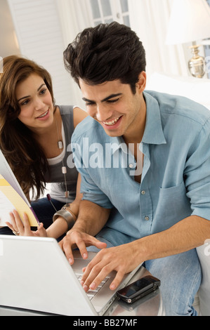 Giovane con un computer portatile e sorridente Foto Stock