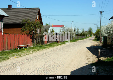 Una vecchia donna seduta su una panchina nel villaggio Soce, Polonia Foto Stock