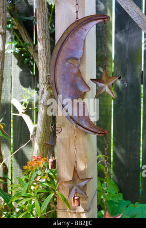 La luna e le stelle di metallo ornamento giardino mobile wind chime pende da una pergola in legno Foto Stock