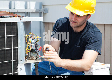 Giovani repairman fissaggio industriale di un compressore della climatizzazione Foto Stock