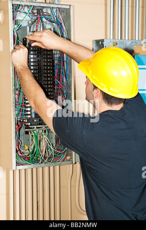 Elettricista cambiare un interruttore in un industriale di grandi dimensioni pannello interruttori Foto Stock