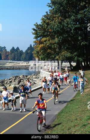 Persone in bicicletta e a piedi il Parco Stanley Seawall in Vancouver British Columbia Canada in estate Foto Stock