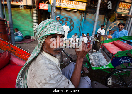Bicicletta Driver Rickshaw bere il tè nella Vecchia Delhi India Foto Stock