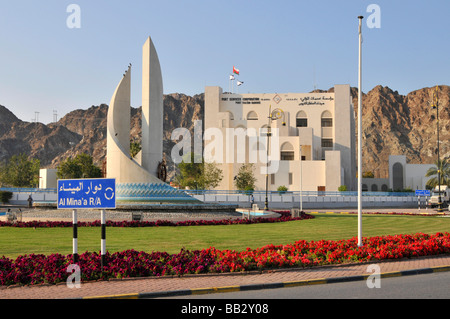 Strade e rotonda ad ingresso a Port Sultan Qaboos Muttrah Muscat Oman con uffici porta al di là di Foto Stock