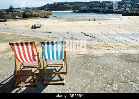 Due sdraio vuota sedervi al sole sul mare a St Ives, Cornwall. Foto Stock