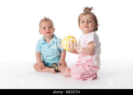 Due bambini seduti sul pavimento con una sfera Foto Stock