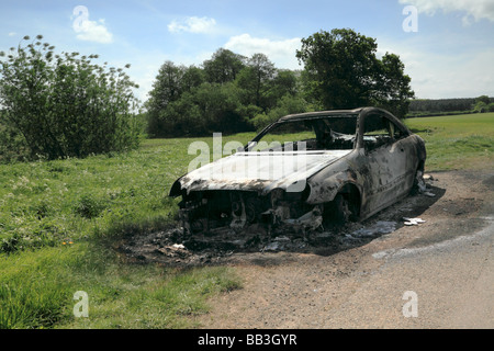 Un bruciato a guscio di una Mercedes Benz Coupe sinistra in terreni agricoli rurale Foto Stock