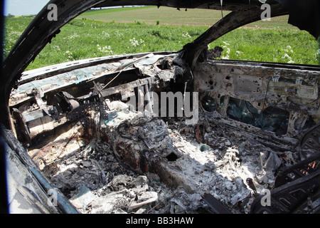 Un bruciato a guscio di una Mercedes Benz Coupe sinistra in terreni agricoli rurale Foto Stock