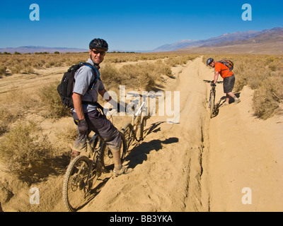 Gli amanti della mountain bike impantanati in profonda sabbia sciolta Foto Stock