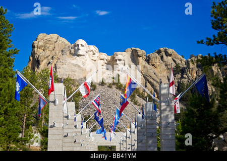 Stati Uniti d'America Sud Dakota. Panoramica del monte Rushmore National Memorial in ore diurne incorniciato da Grand View terrazza con le bandiere in primo piano Foto Stock