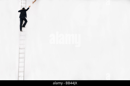 Uomo in business suit sale una scala alta, San Diego, California. Foto Stock
