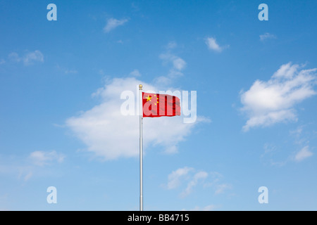 Una bandiera cinese vola contro un cielo blu Foto Stock