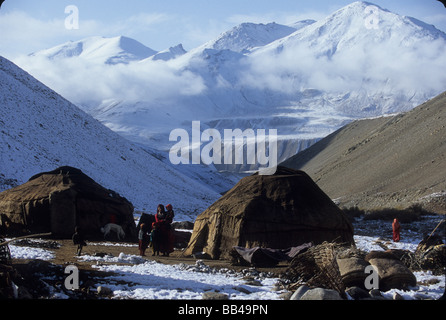 Una pausa di famiglia al di fuori della loro yurta presso un' pastori camp circondata da cime coperte di neve, nella grande Pamir, Wakhan Corridor, B Foto Stock