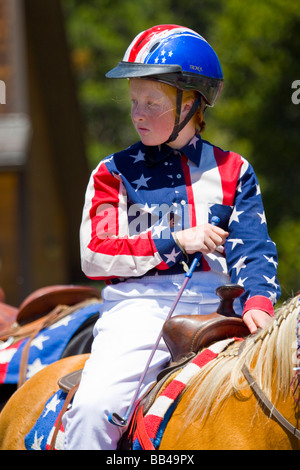 Stati Uniti d'America, Colorado, Frisco. La ragazza di bandiera colori passeggiate a cavallo nel luglio 4° parata. Foto Stock