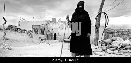 Vecchia donna vestita di nero in piedi di fronte alla sua casa a el-Qurna - piccolo villaggio nei pressi di Luxor,l'Egitto. Foto Stock