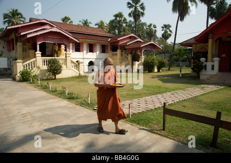 Un Monaco a piedi attraverso i motivi di un tempio birmano in Chiang Mai Foto Stock