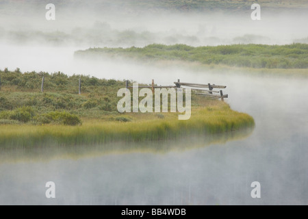 Stati Uniti d'America, Wyoming Green River. Nebbia di mattina si deposita sul suolo erboso e della curvatura del fiume. Foto Stock