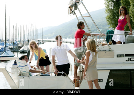 Gruppo giovane su uno yacht in un porto Foto Stock