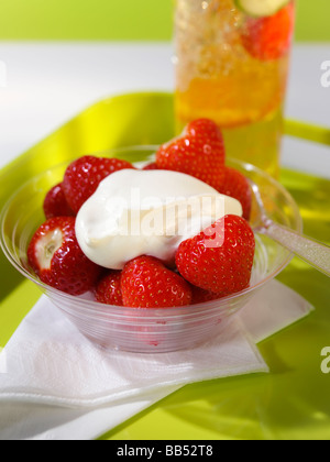 Fragole e panna con un bicchiere di Pimms Foto Stock
