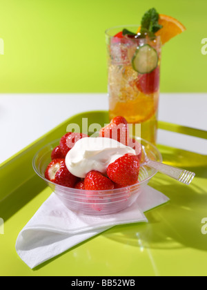 Fragole e panna con un bicchiere di Pimms Foto Stock