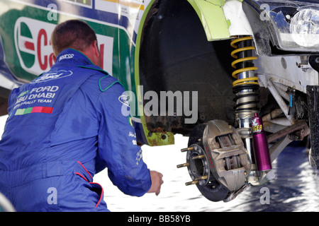 Una meccanica che fissa una Ford Focus al Sardinia World Rally Championship Foto Stock