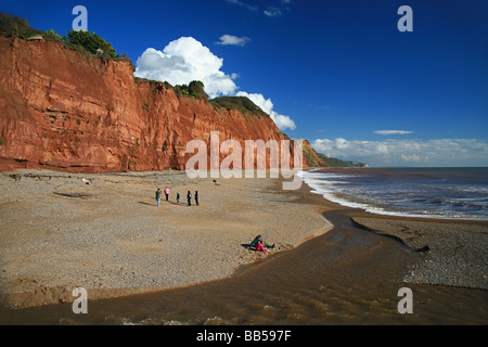 Il rosso scogliere di arenaria del "Jurassic Coast' e la Sid di fiume che scorre attraverso la spiaggia a Sidmouth, nel Devon, Inghilterra, Regno Unito Foto Stock