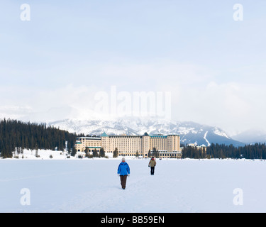 Il Fairmont Chateau Lake Louise hotel circondato da montagne coperte di neve e di fronte al lago ghiacciato Foto Stock