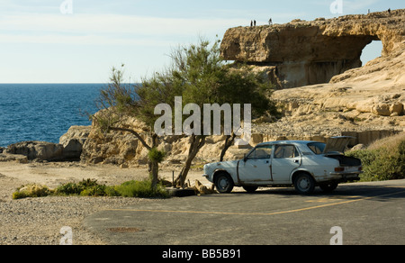 Una macchina parcheggiata a Dwejra Point con il suo bagagliaio aperto in un altrimenti vuota parcheggio auto da Azure Window sull'isola Maltese di Gozo Foto Stock