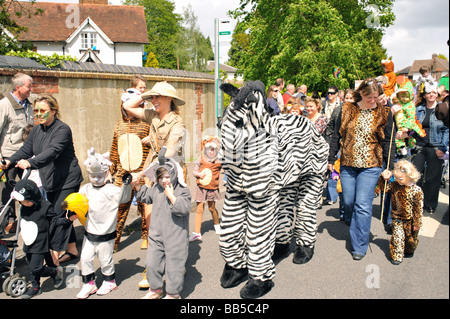 Bambini e genitori vestiti come animali da zoo a camminare in una sfilata di carnevale attraverso Walton sulla collina Surrey UK Foto Stock